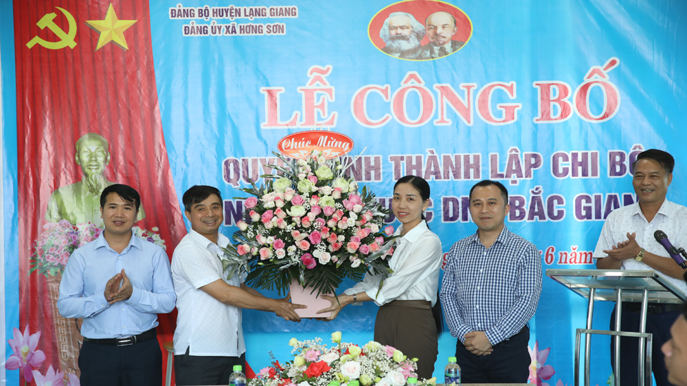 Đồng chí Ngô Thanh Linh, Phó Bí thư Thường trực Huyện ủy Lạng Giang tặng hoa chúc mừng Chi bộ Nhà máy nước DNP Bắc Giang.