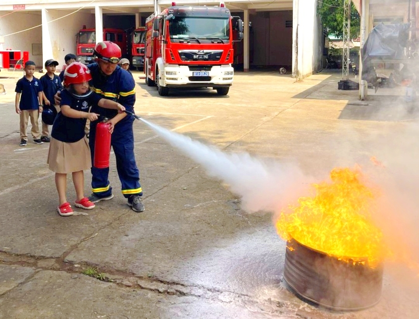 Học sinh Trường Tiểu học, THCS và THPT UKA Gia Lai thực hành kỹ năng sử dụng bình chữa cháy để dập tắt đám cháy. Ảnh: Trần Lương