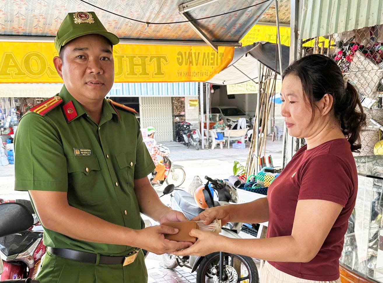 Thiếu tá Trần Quan Chung, Phó Trưởng Công an xã Định Mỹ tiếp nhận tài sản bị đánh rơi