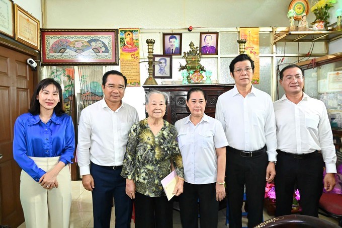 Đồng chí Nguyễn Văn Được và các đại biểu chụp hình lưu niệm cùng mẹ Việt Nam anh hùng Nguyễn Thị Hữu Tài và gia đình. (Ảnh: SGGP)