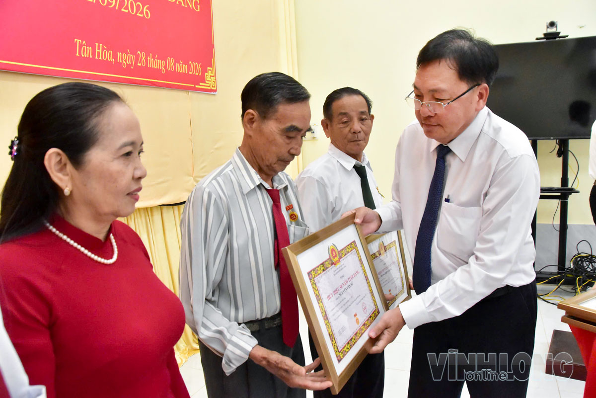 Đồng chí Tăng Chí Huấn, Tỉnh ủy viên, Phó Giám đốc Báo và phát thanh, truyền hình Vĩnh Long, Giám đốc Trung tâm Báo Vĩnh Long trao Huy hiệu 50 năm tuổi Đảng cho đảng viên Nguyễn Văn Nữ.    Ảnh: MỸ NHÂN