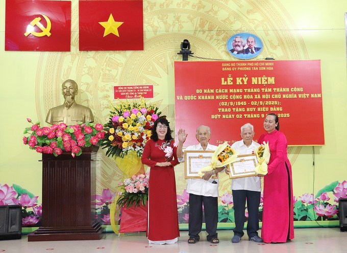 Đồng chí Trương Lê Mỹ Ngọc và Phó Bí thư Thường trực Đảng ủy phường Nguyễn Thị Tuyết Lệ Sương trao Huy hiệu Đảng đến các đảng viên