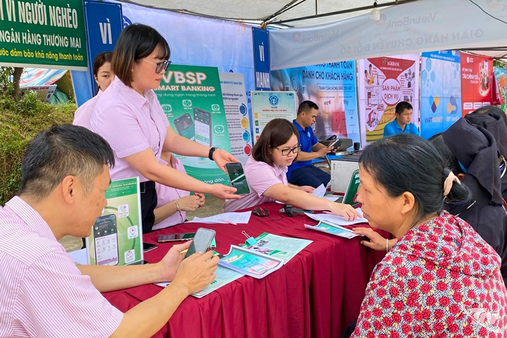 Cán bộ Ngân hàng CSXH hỗ trợ khách hàng cài đặt ứng dụng VBSP Smart Banking.