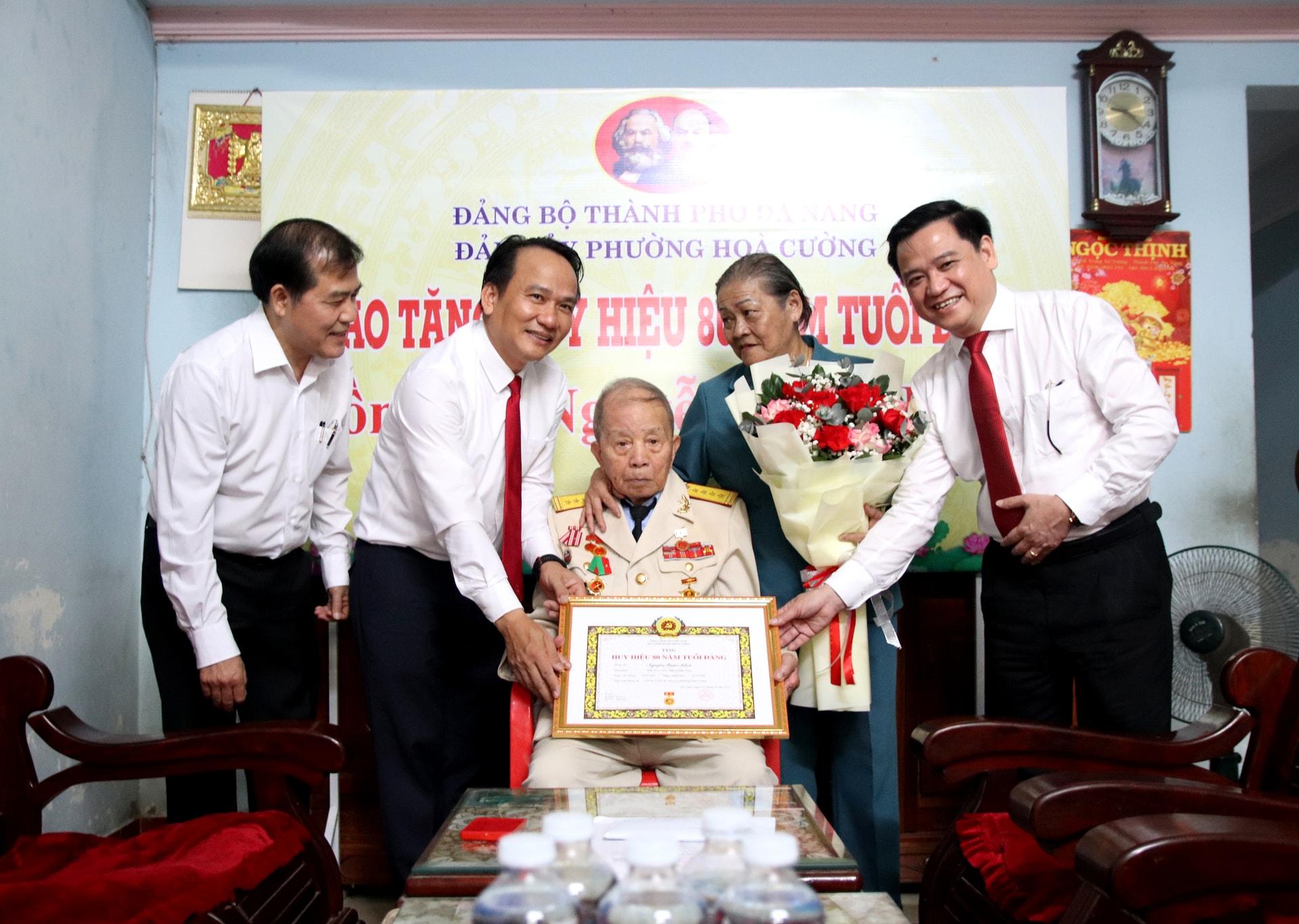 Phó Bí thư Thường trực Thành ủy Nguyễn Đình Vĩnh (thứ 2, trái sang) trao Huy hiệu 80 năm tuổi Đảng cho đảng viên Nguyễn Xuân Khoa. Ảnh: TRỌNG HUY