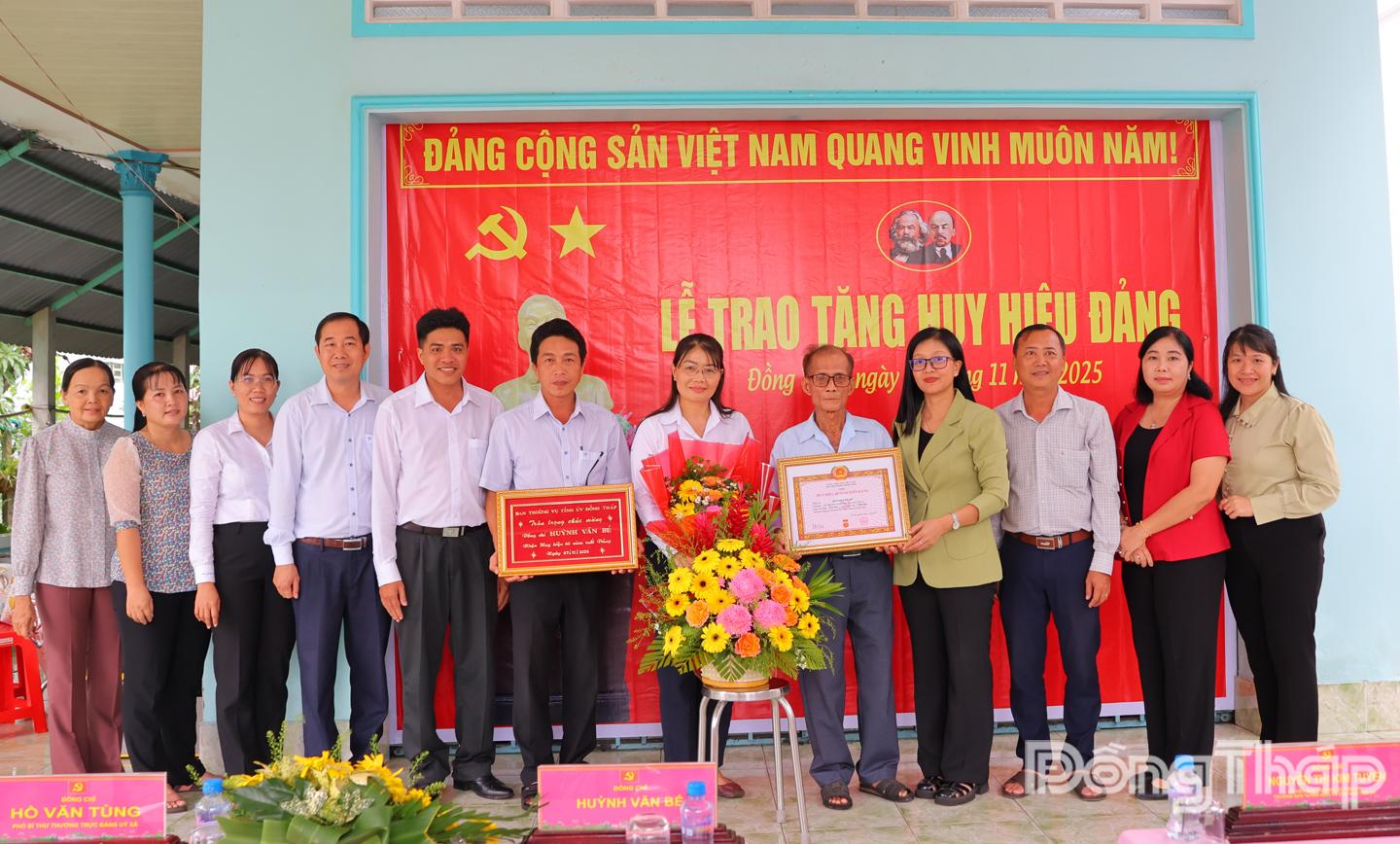 Đồng chí Nguyễn Thị Kim Tuyến, Ủy viên Ban Thường vụ Tỉnh ủy, Trưởng Ban Tuyên giáo và Dân vận Tỉnh ủy Đồng Tháp cùng đại diện cấp uỷ xã Mỹ Thọ chụp ảnh lưu niệm cùng đảng viên Huỳnh Văn Bé.