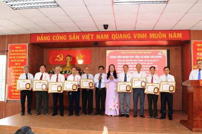 Phó Bí thư Thường trực Đảng ủy phường Bình Trị Đông Nguyễn Thị Bé Hai trao Huy hiệu 45 năm tuổi Đảng đến các đồng chí đảng viên