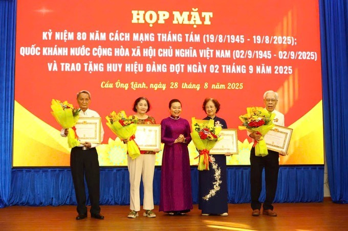 Lãnh đạo phường Cầu Ông Lãnh trao Huy hiệu Đảng đến đảng viên. (Ảnh: SGGP)