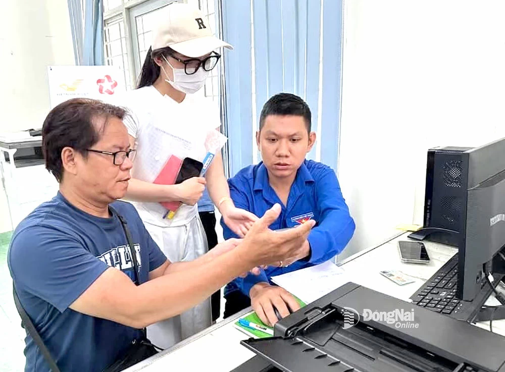 Cán bộ Đoàn xã Dầu Giây hướng dẫn người dân thực hiện dịch vụ công trực tuyến tại Trung tâm Phục vụ hành chính công của xã. Ảnh: Phương Hằng