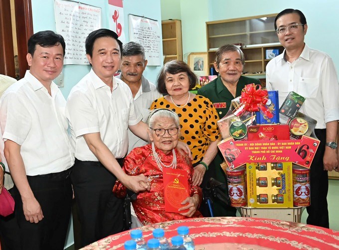 Phó Bí thư Thành ủy TPHCM Đặng Minh Thông và Bí thư Đảng ủy phường Diên Hồng Lê Văn Minh trao quà đến bà Trần Thị Phát. (Ảnh: SGGP)