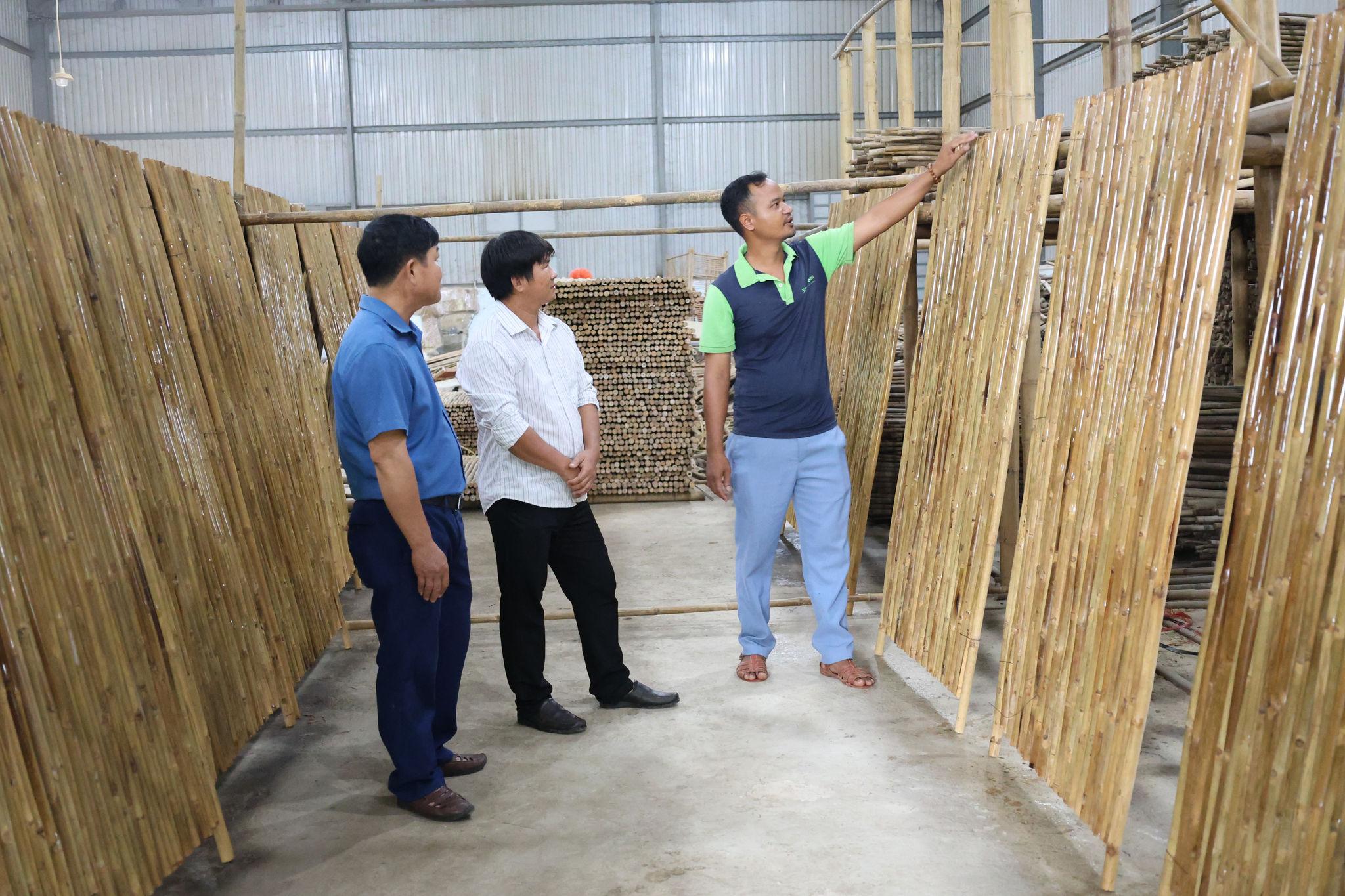 Anh K'Mưn (bên phải) giới thiệu các công đoạn tạo ra sản phẩm tại Hợp tác xã sơ chế tre tầm vông Tố Lan