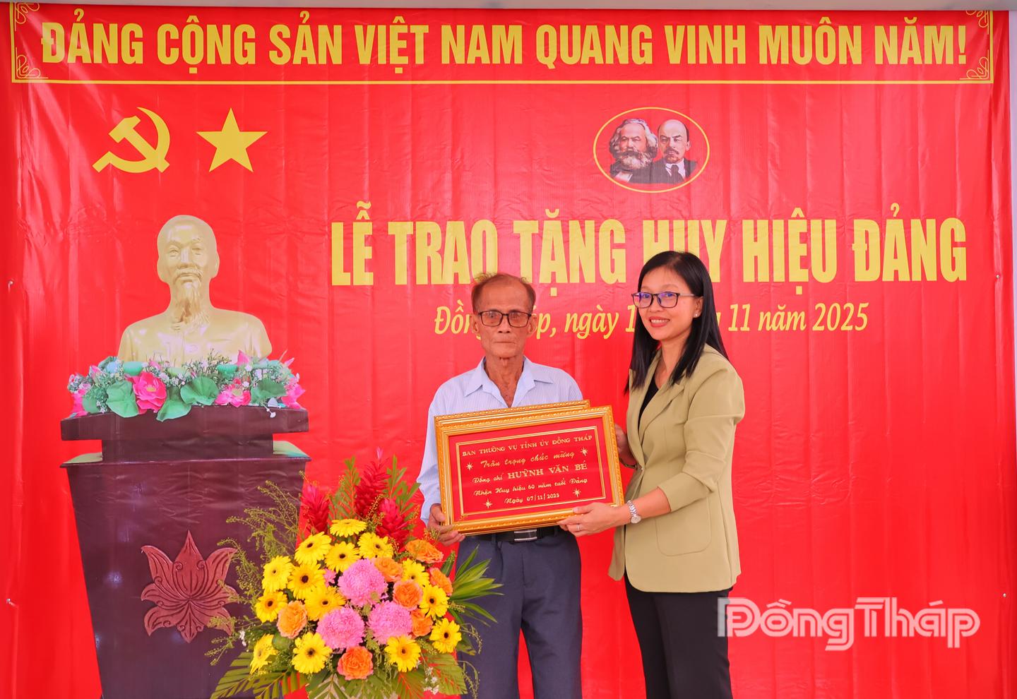 Đồng chí Nguyễn Thị Kim Tuyến, Ủy viên Ban Thường vụ Tỉnh ủy, Trưởng Ban Tuyên giáo và Dân vận Tỉnh ủy Đồng Tháp trao huy hiệu Đảng cho đảng viên Huỳnh Văn Bé.