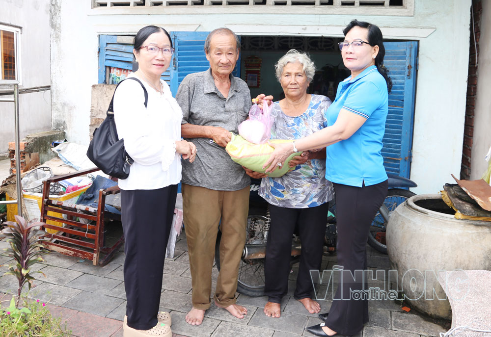 Bà Nguyễn Thị Ngọc Mai- Chi hội trưởng Chi hội Phụ nữ khóm Long Bình tặng gạo  cho người cao tuổi hoàn cảnh khó khăn.