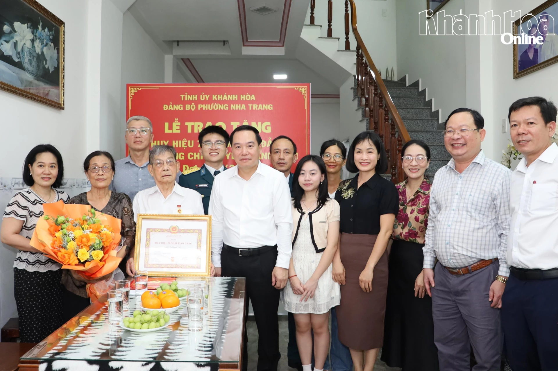 Đồng chí Hồ Xuân Trường và các đại biểu chụp ảnh lưu niệm cùng đảng viên Nguyễn Mạnh Tiến.