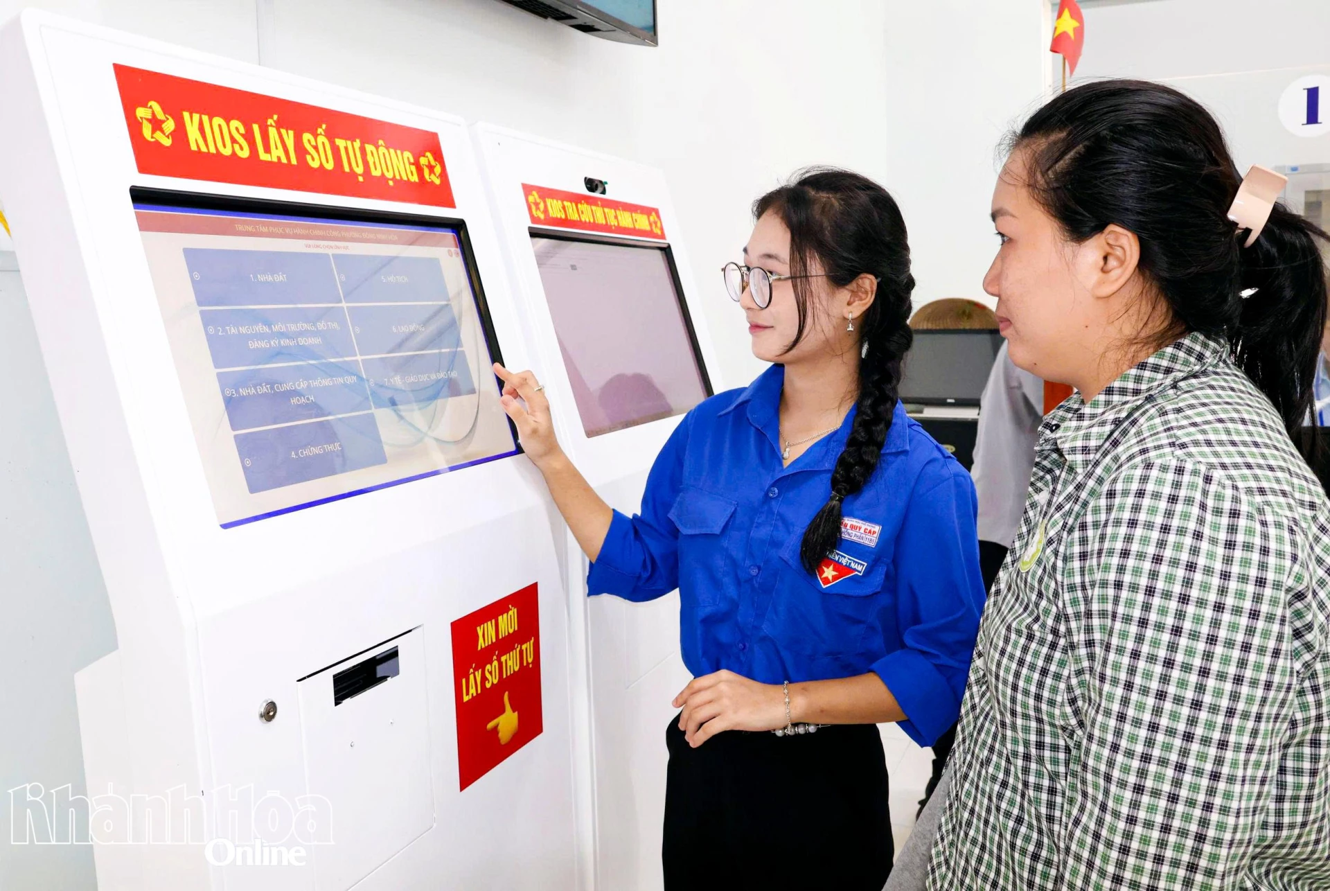 Đoàn viên phường Đông Ninh Hòa hướng dẫn người dân lấy số thứ tự thực hiện thủ tục hành chính.
