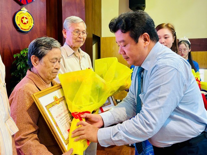 Đồng chí Nguyễn Trần Phú trao Huy hiệu Đảng và tặng hoa chúc mừng các đảng viên