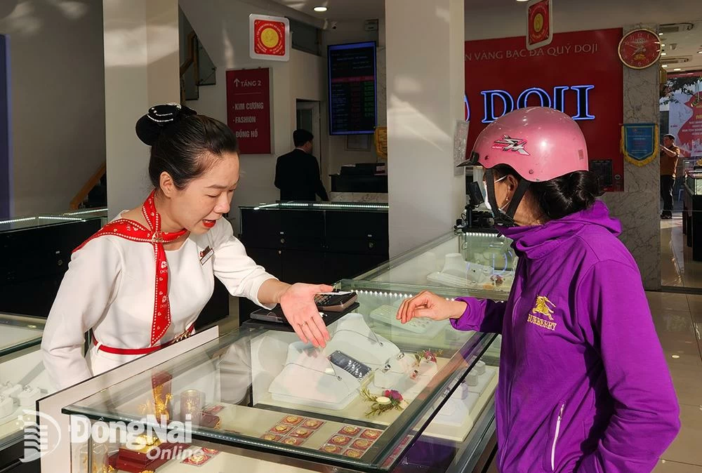 Người dân tham khảo các loại vàng miếng, nữ trang tại một trung tâm vàng bạc, trang sức ở phường Trấn Biên. Ảnh: Hải Quân