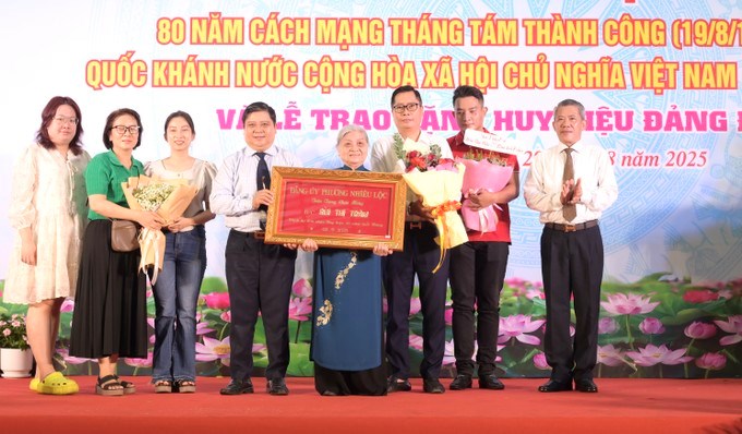 Đồng chí Nguyễn Chí Trung trao Huy hiệu 60 năm tuổi Đảng đến đồng chí Bùi Thị Trâm. (Ảnh: SGGP)