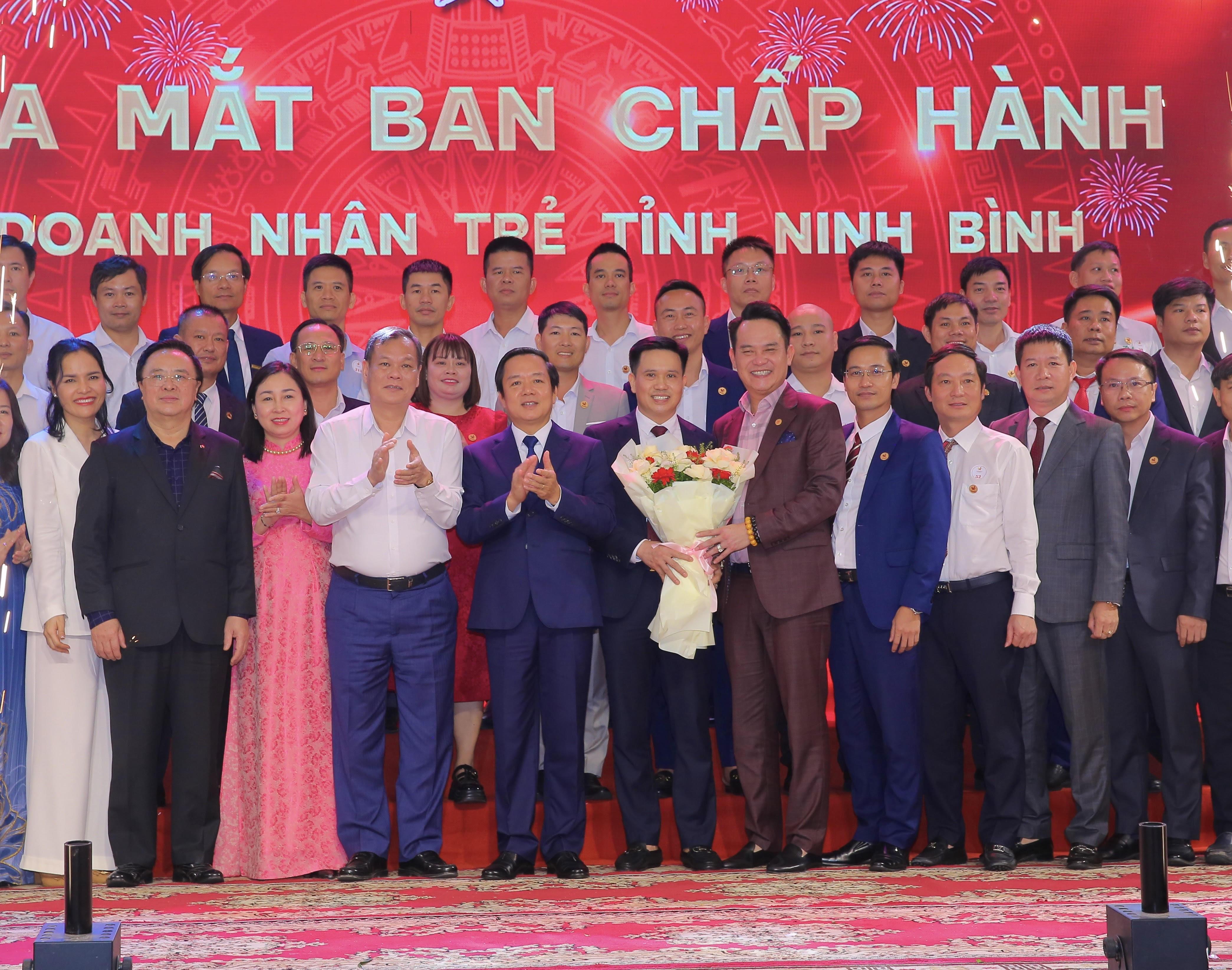 Đồng chí Hoàng Bình Quân, nguyên Ủy viên Trung ương Đảng, nguyên Trưởng Ban Đối ngoại Trung ương, Chủ tịch danh dự Hội Doanh nhân trẻ Việt Nam và các đồng chí lãnh đạo tỉnh tặng hoa chúc mừng Ban Chấp hành Hội Doanh nhân trẻ tỉnh Ninh Bình.