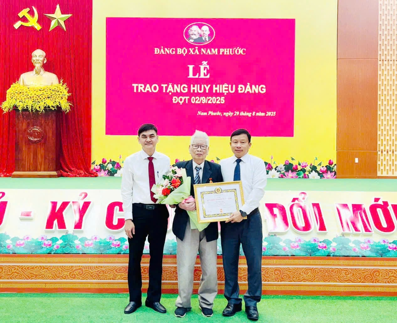 Trưởng ban Tổ chức Thành ủy Đà Nẵng Đoàn Duy Tân (bên phải) và ông Cao Thanh Hải - Thành ủy viên, Bí thư Đảng ủy, Chủ tịch HĐND xã Nam Phước (bên trái) trao tặng Huy hiệu 70 năm tuổi Đảng cho đảng viên Ngô Đình Tường. Ảnh: V.S