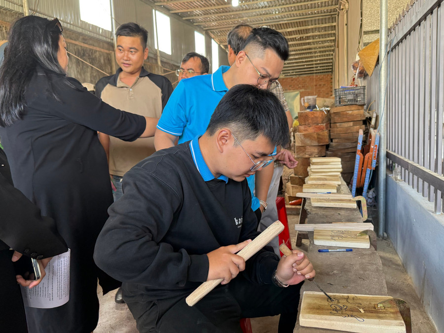 Các đại biểu tham quan, trải nghiệm thực hành sản phẩm gỗ tại nhà ông Nguyễn Văn Bá, khu phố Vân Sơn, phường An Nhơn. Ảnh: Ngô Sương 3.jpg