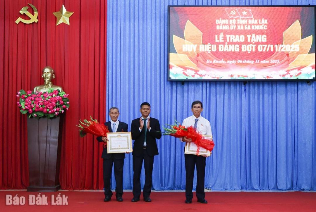 Phó Bí thư Thường trực Đảng ủy xã Ea Knuếc Y Thưa Kbuôr trao Huy hiệu 45 năm tuổi Đảng cho đảng viên Quách Minh Ngoạn (Chi bộ 7) và đảng viên Dương Sinh (Chi bộ 7).