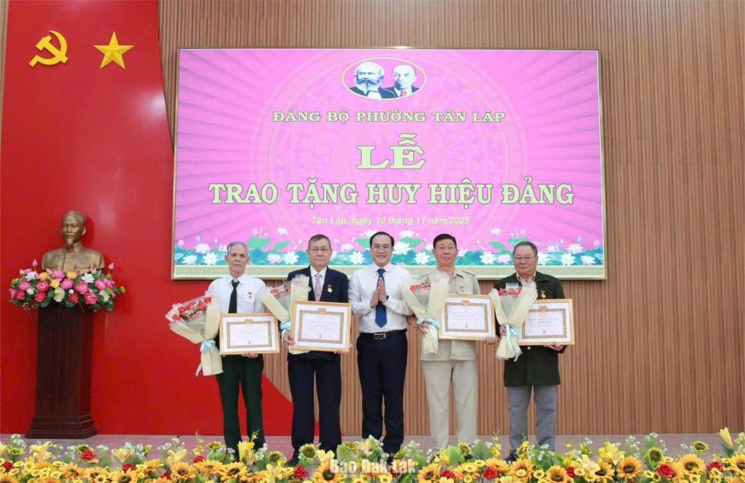 Phó Bí thư Đảng ủy, Chủ tịch UBND phường Tân Lập Trần Đức Nhật trao Huy hiệu 50 năm tuổi Đảng cho các đảng viên.