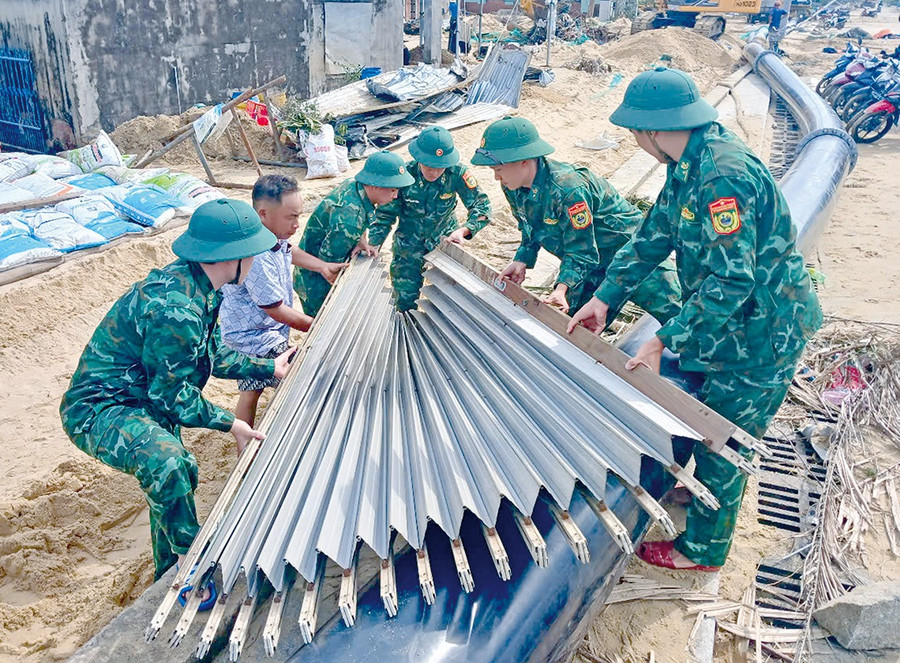 Lực lượng quân đội làm theo lời Bác Hồ dạy: 'Vì nhân dân phục vụ', cùng nhau giúp đỡ người dân xã Đề Gi khắc phục hậu quả bão số 13, ổn định cuộc sống. Ảnh: N.H