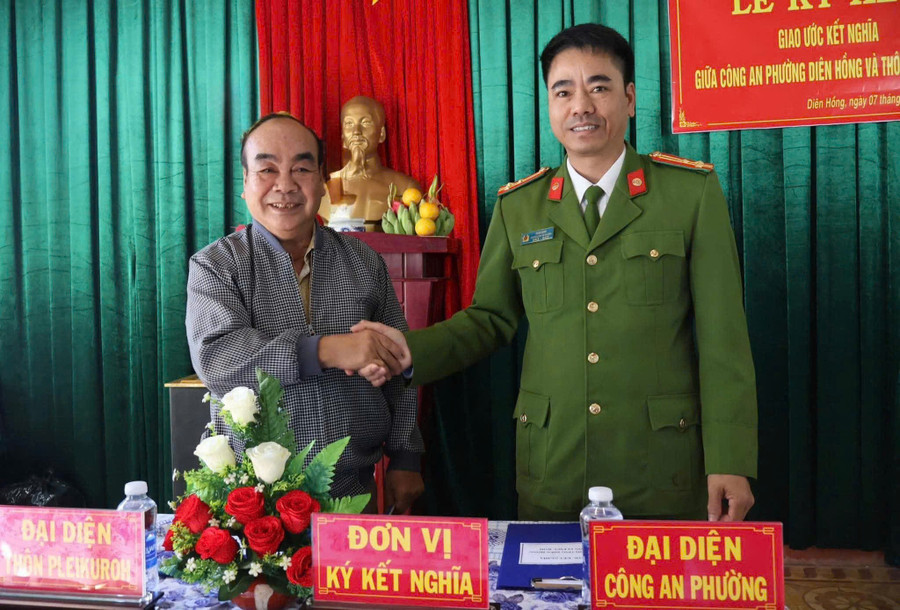 Thượng tá Ksor Định-Trưởng Công an phường Diên Hồng và ông Đỗ Văn Lợi-Bí thư Chi bộ làng Pleiku Roh ký giao ước kết nghĩa giữa 2 đơn vị. Ảnh: ĐVCC z7302943976534-2fd2adf6d5c6e11b0312d27f49df174e.jpg