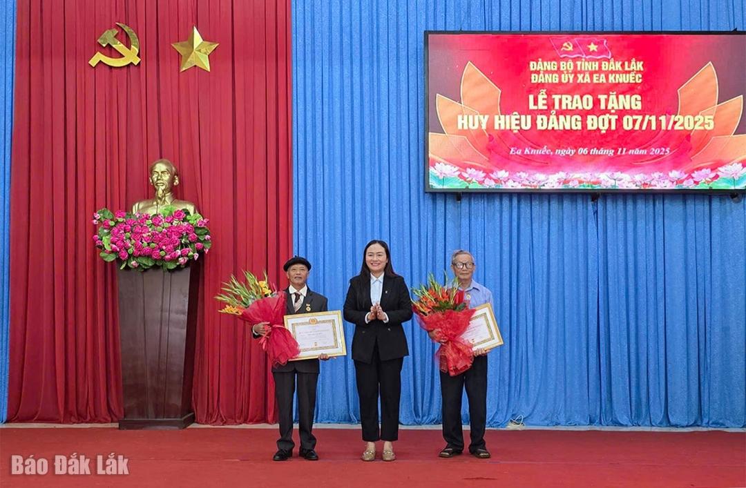 Bí thư Đảng ủy, Chủ tịch HĐND xã Ea Knuếc Ngô Thị Minh Trinh trao Huy hiệu 50 năm tuổi Đảng cho đảng viên Nguyễn Văn Sửu (Chi bộ thôn Hòa An) và đảng viên Võ Đình Năm (Chi bộ 12).