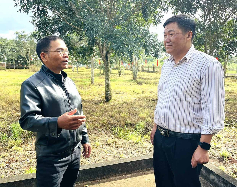 Ông Yôl (bìa trái) trao đổi về việc triển khai các phong trào, cuộc vận động của thôn với Chủ tịch Ủy ban MTTQ Việt Nam xã Kon Gang.