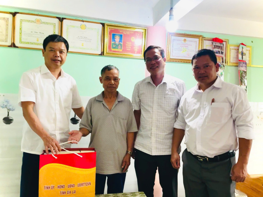Phó Chủ tịch UBND tỉnh Nguyễn Hữu Quế (bìa trái) tặng quà cho thương binh Lê Văn Đung (ở làng Hà Giao, xã Canh Liên). Ảnh: Phi Long pct-ubnd-tinh-nguyen-huu-que-bia-trai-tham-tang-qua-thuong-binh-le-van-dung-lang-ha-giao-xa-canh-lien.jpg