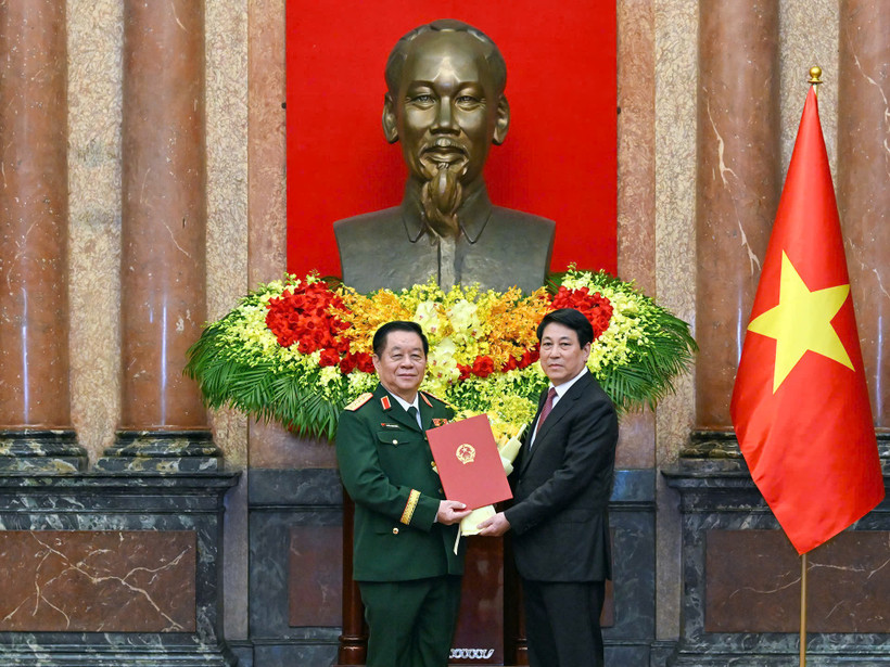 Chủ tịch nước Lương Cường trao quyết định và tặng hoa chúc mừng đồng chí Nguyễn Trọng Nghĩa. (Ảnh: THỦY NGUYÊN)