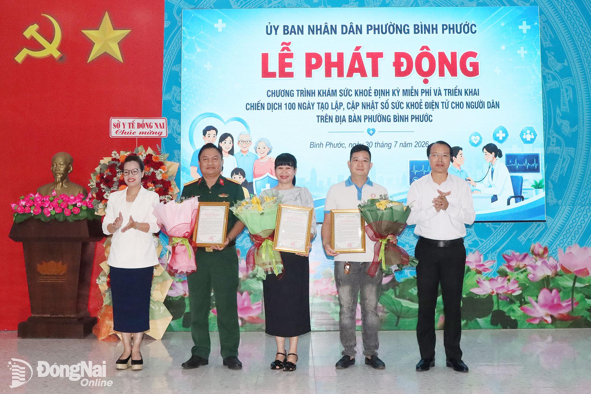 Lãnh đạo phường Bình Phước tặng hoa và thư cảm ơn các đơn vị y tế đồng hành cùng chương trình. Ảnh: Quang Minh