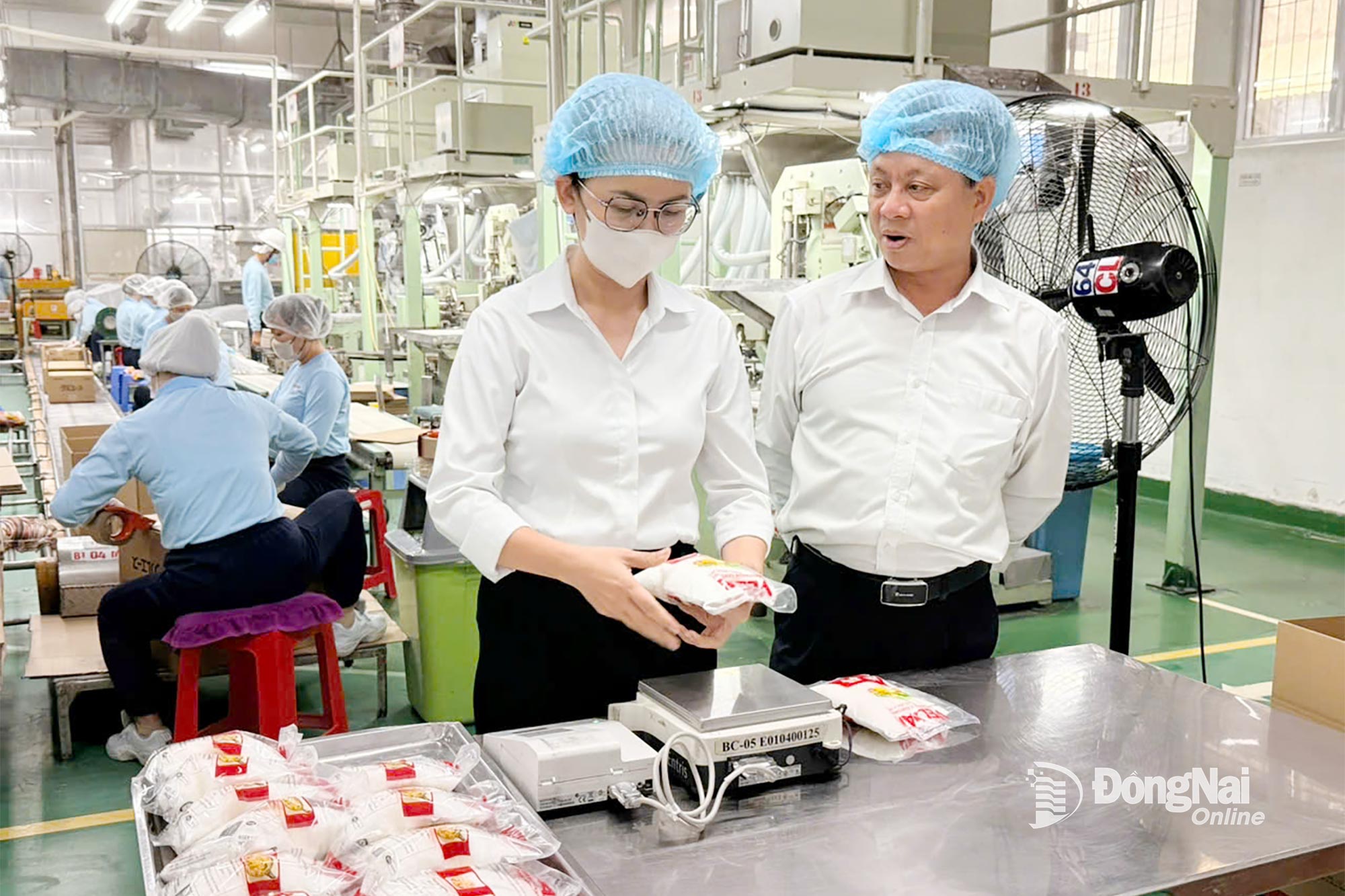 Bí thư Đảng ủy Công ty cổ phần hữu hạn Vedan Việt Nam Phạm Trung Thuyên trao đổi với đảng viên Nguyễn Thị Thúy Hoa tại xưởng sản xuất. Ảnh: Nguyễn Hòa