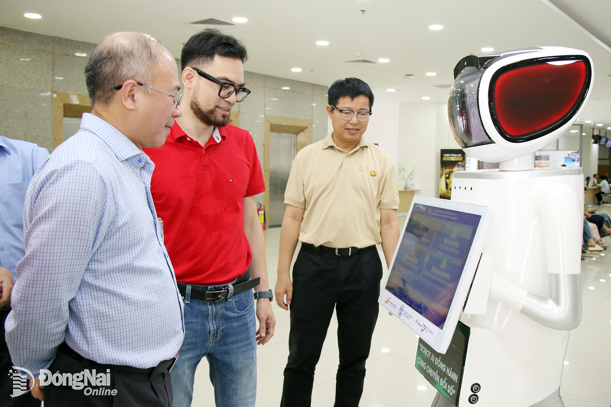 Tiến sĩ Nguyễn Văn Tân, Phó Hiệu trưởng Trường đại học Lạc Hồng (bìa phải) khảo sát hoạt động thử nghiệm robot AI phục vụ người dân tại Trung tâm Phục vụ hành chính công thành phố Đồng Nai.