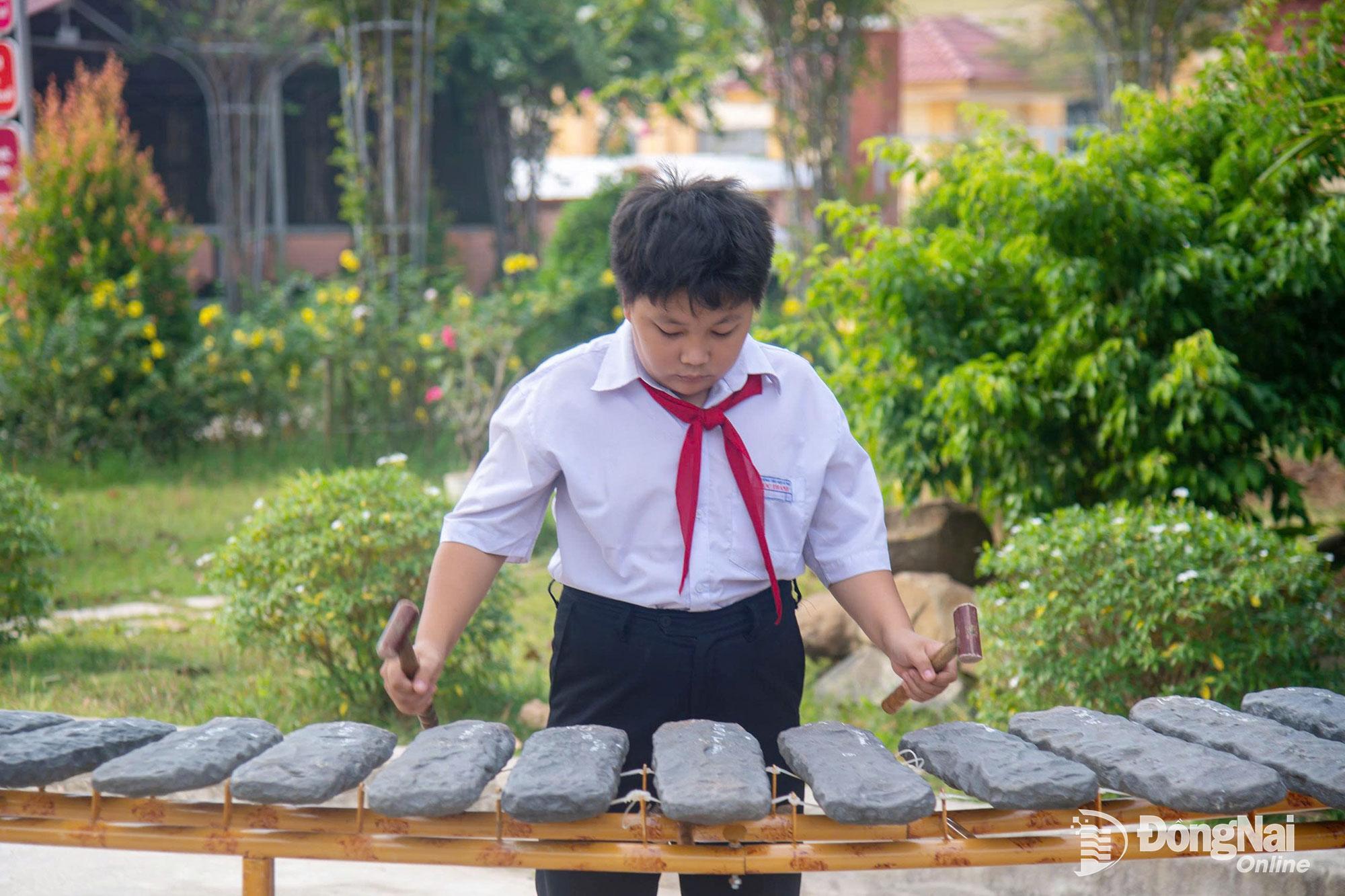 Em Phan Hoàng Bảo Long trong một buổi trình diễn đàn đá tại sân trường. Ảnh: Văn Chung