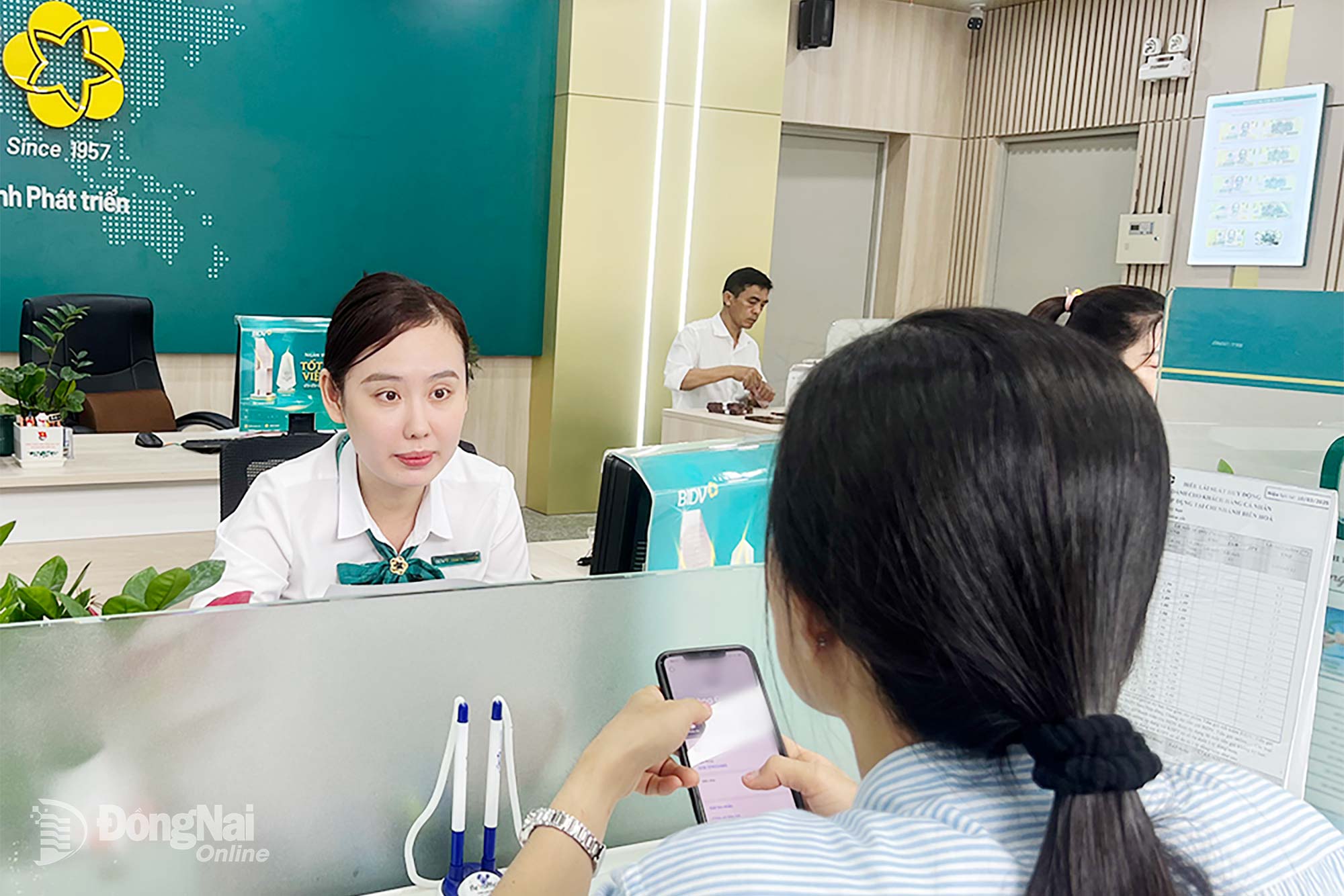 Nhân viên Ngân hàng BIDV chi nhánh Biên Hòa (phường Trấn Biên) hướng dẫn khách hàng sử dụng các tiện ích, dịch vụ trực tuyến thông qua ứng dụng ngân hàng số. Ảnh: Hải Quân