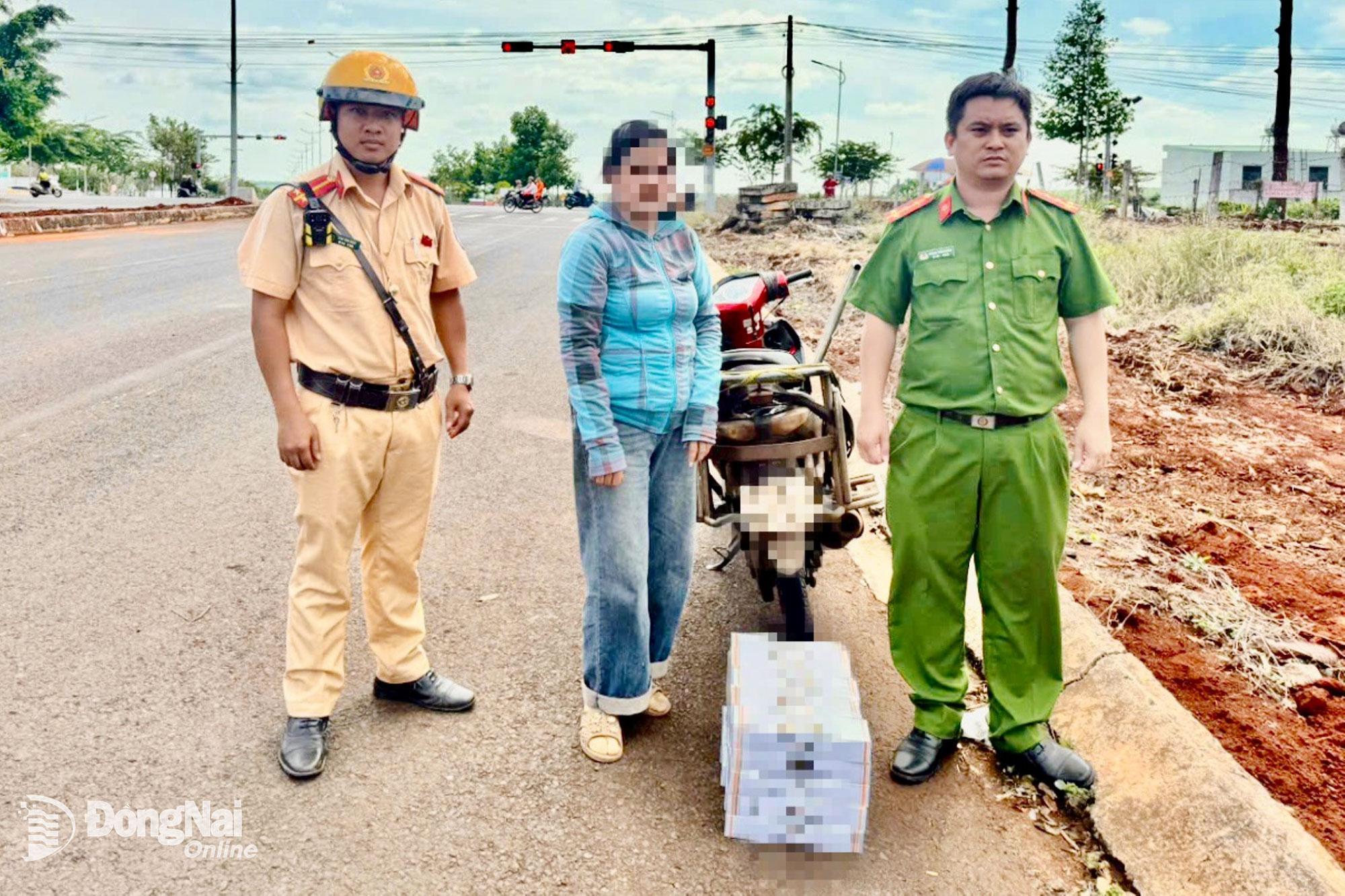 Bà N.T.T.L. (47 tuổi, ngụ tỉnh Đồng Nai) cùng 250 bao thuốc lá điếu nhãn hiệu J. không có giấy tờ chứng minh nguồn gốc. Ảnh: Bảo Long