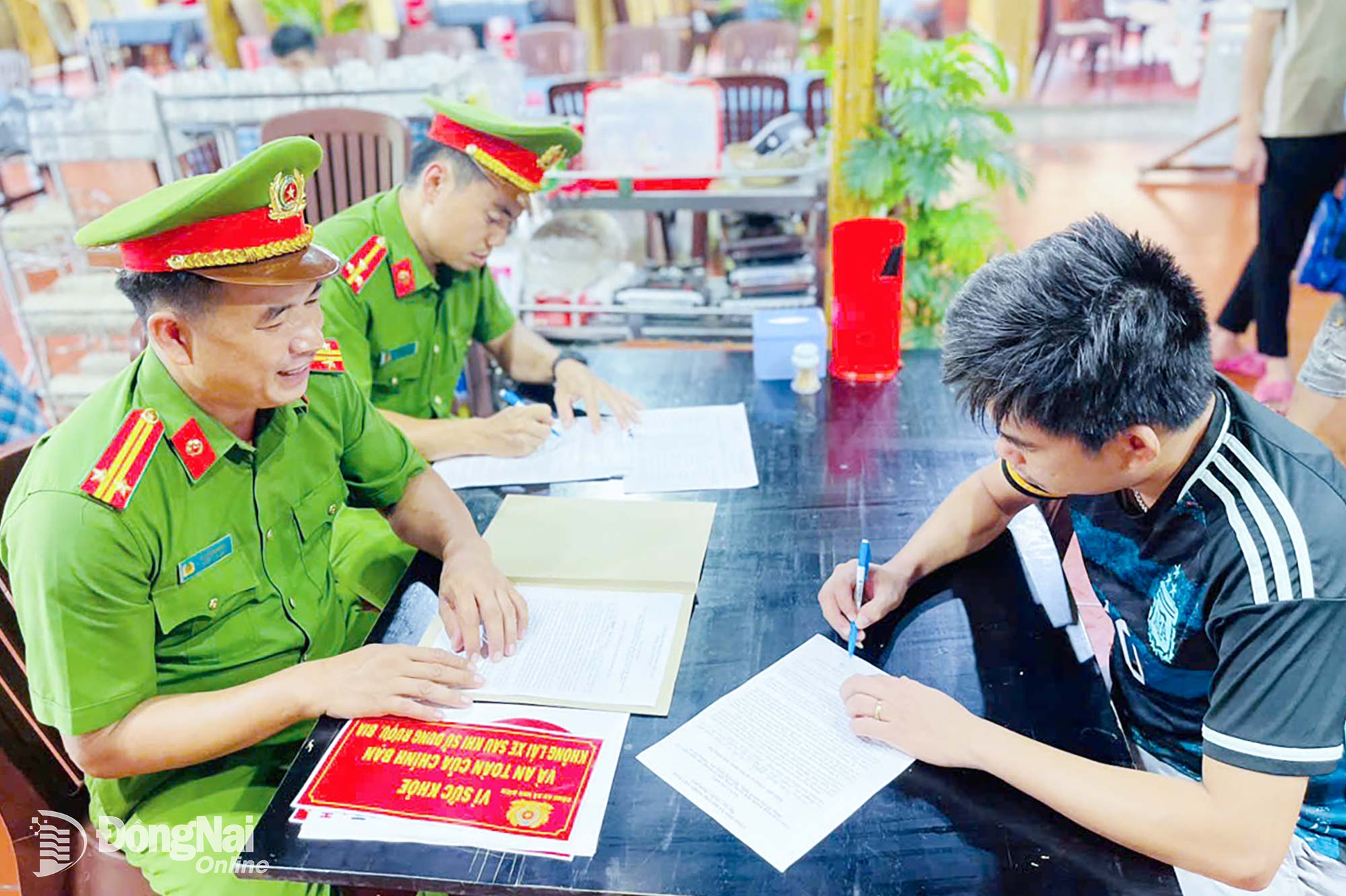 Công an xã Nha Bích tổ chức cho các chủ cơ sở kinh doanh dịch vụ ký cam kết thực hiện chấp hành pháp luật. Ảnh: Trần Danh