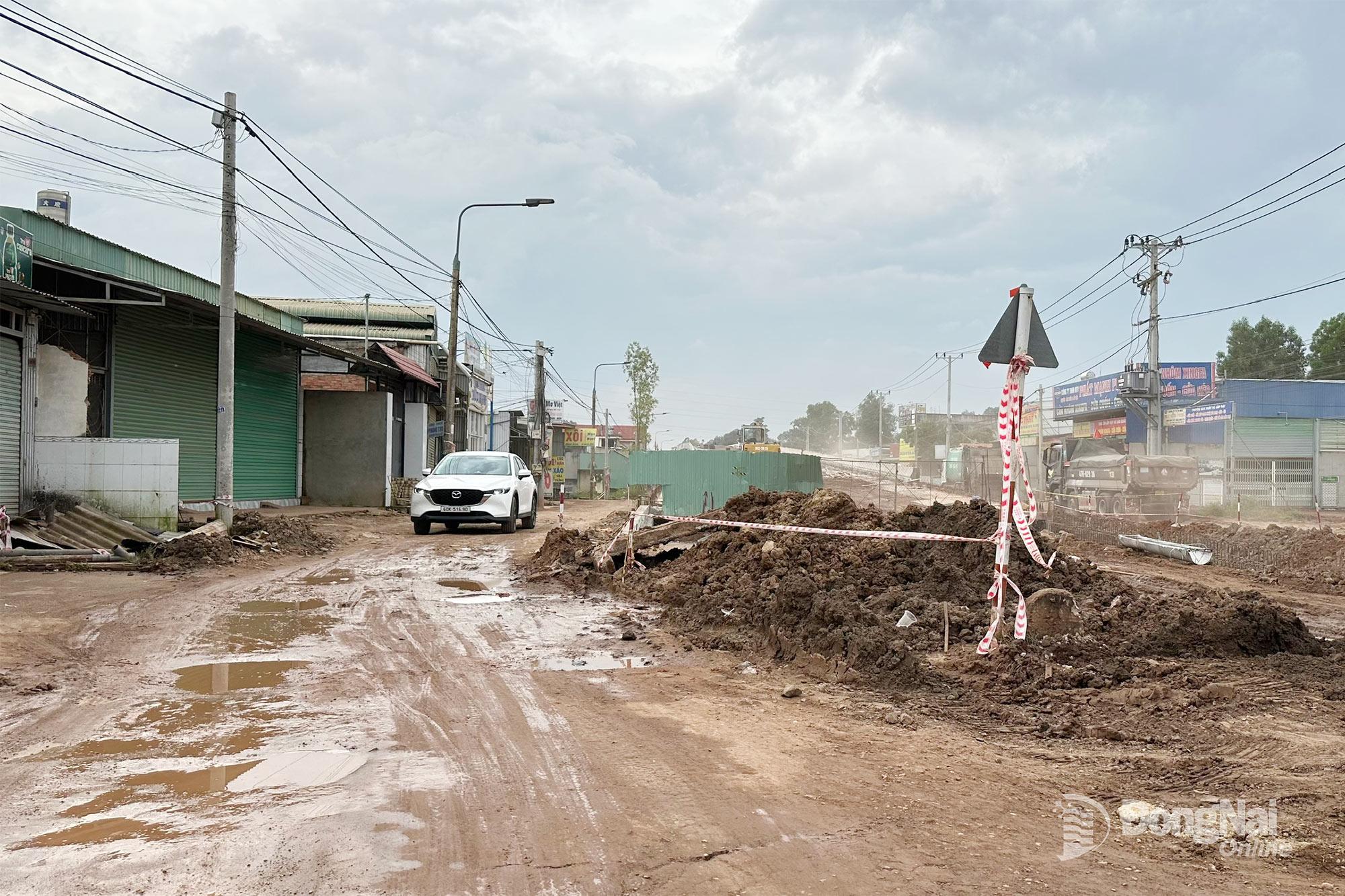 Các phương tiện lưu thông qua công trường thi công nút giao cầu vượt đường Bàu Cạn (thuộc xã Long Phước). Ảnh: Thùy Linh