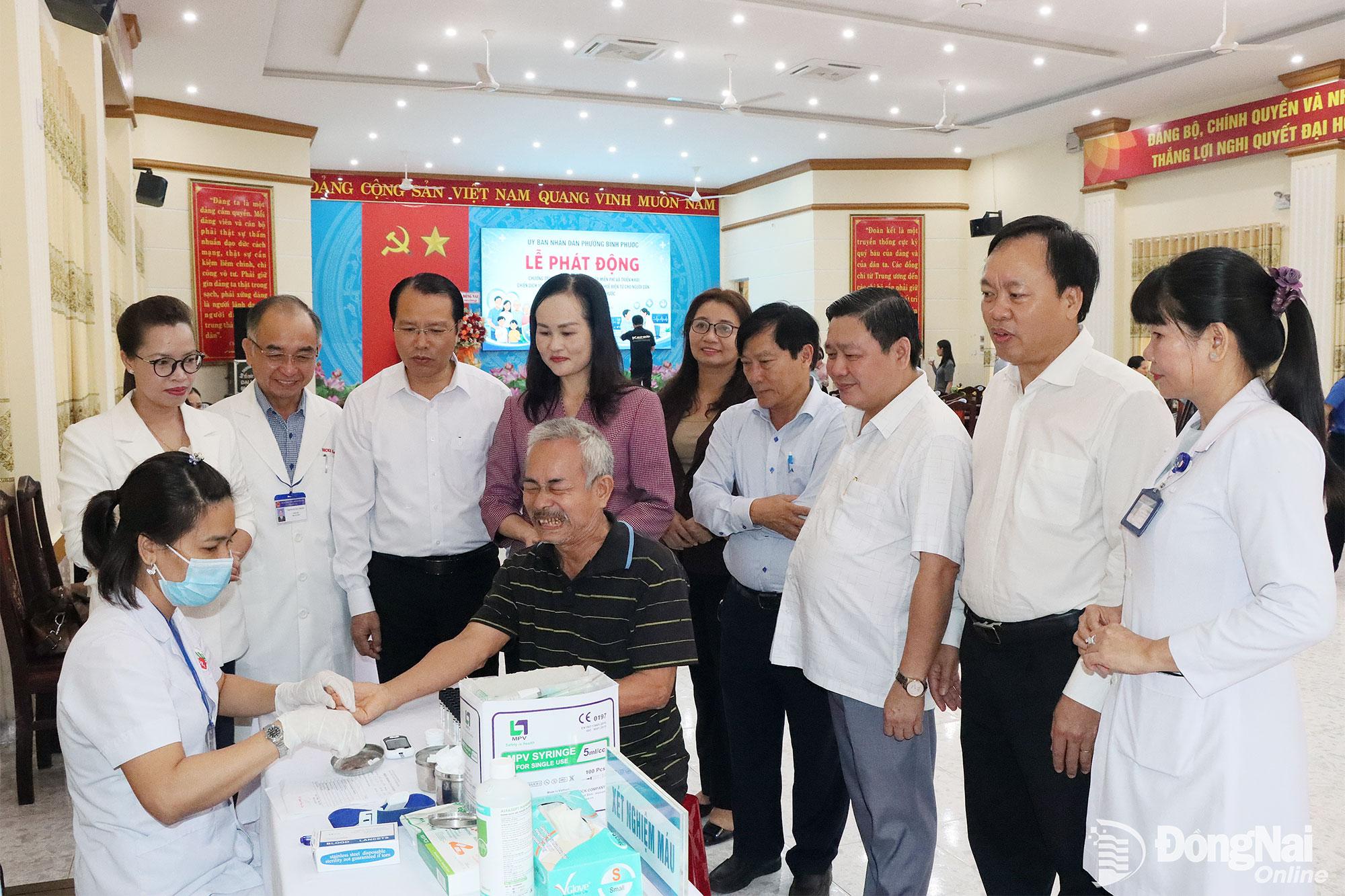 Lãnh đạo phường Bình Phước thăm, động viên các y, bác sĩ thực hiện công tác khám bệnh sau lễ phát động. Ảnh: Quang Minh