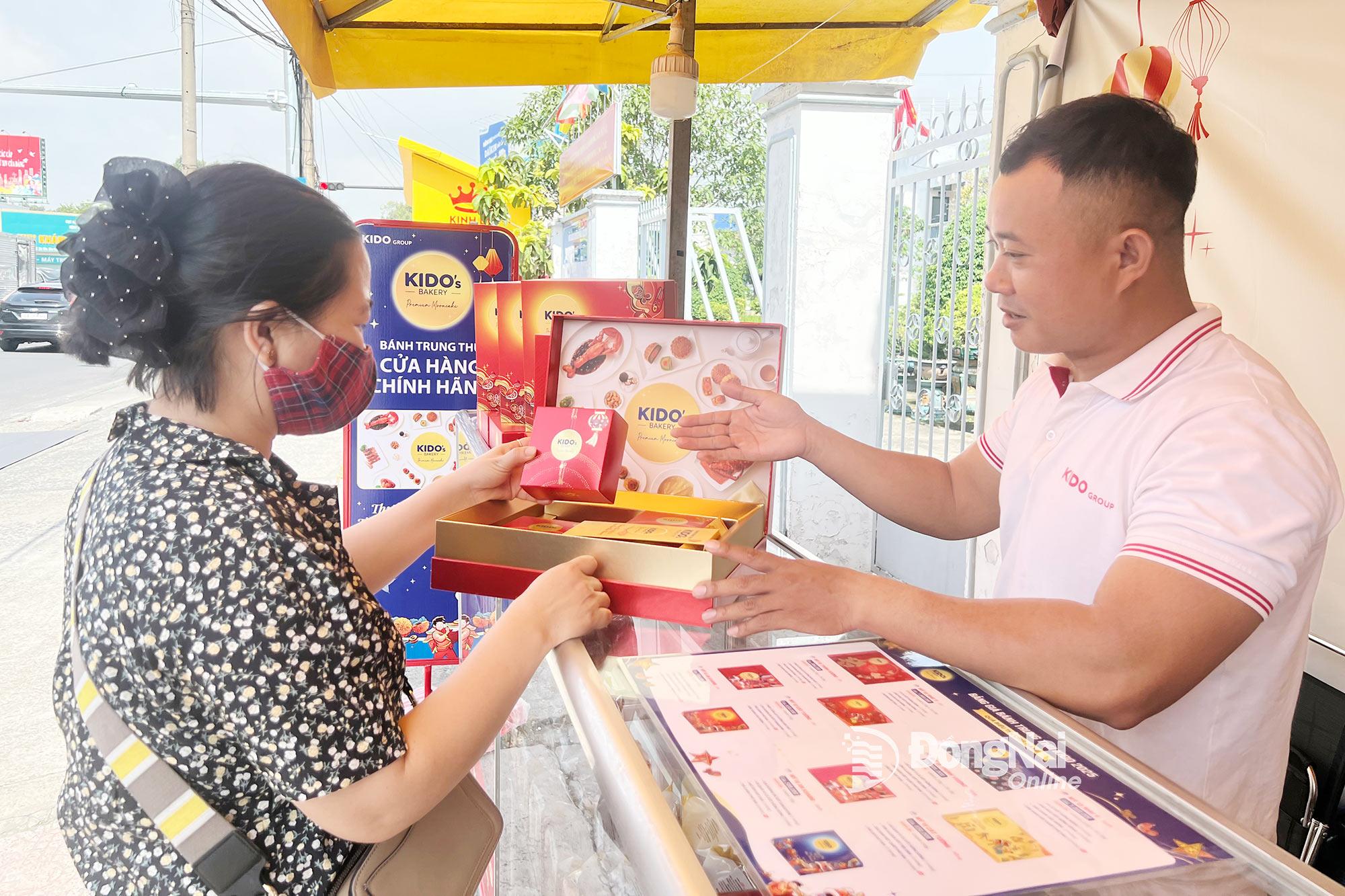 Người tiêu dùng tham khảo, chọn mua bánh trung thu tại một sạp hàng trên đường Nguyễn Ái Quốc (phường Trảng Dài). Ảnh: Hải Quân