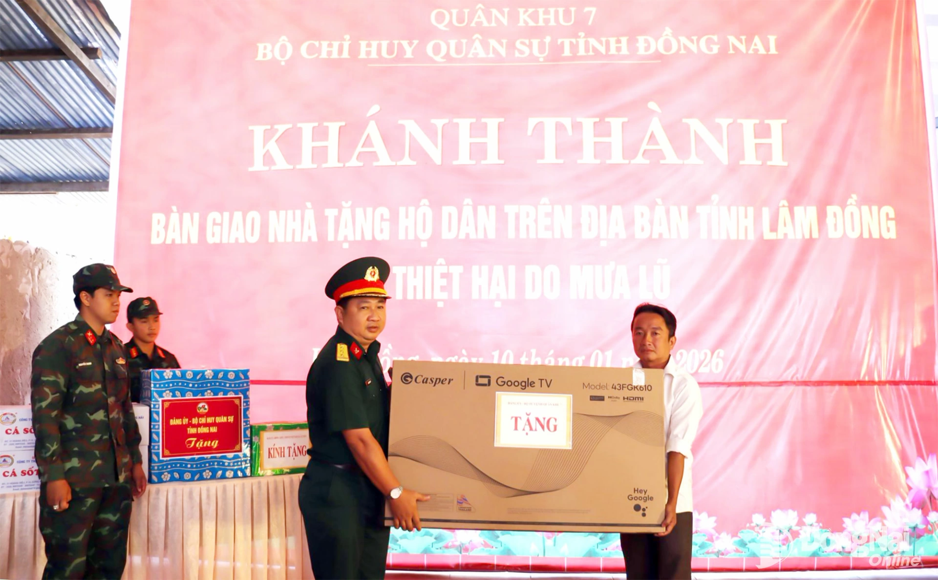 Thượng t&aacute; Nguyễn Minh Hiếu, Ph&oacute; Trưởng ph&ograve;ng Doanh trại, Cục Hậu cần - Kỹ thuật Qu&acirc;n khu 7 trao ảnh B&aacute;c, cờ Tổ quốc v&agrave; tặng qu&agrave; cho gia đ&igrave;nh người d&acirc;n bị ảnh hưởng thi&ecirc;n tai. Ảnh: Nguyệt H&agrave;
