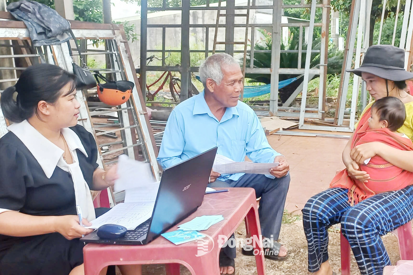 Ông Điểu Đé (thôn Hai Căn, xã Phú Nghĩa, tỉnh Đồng Nai) hỗ trợ nhân viên Trạm Y tế xã tiếp nhận và lấy thông tin của người dân đưa con đi tiêm chủng. Ảnh: C.T.V