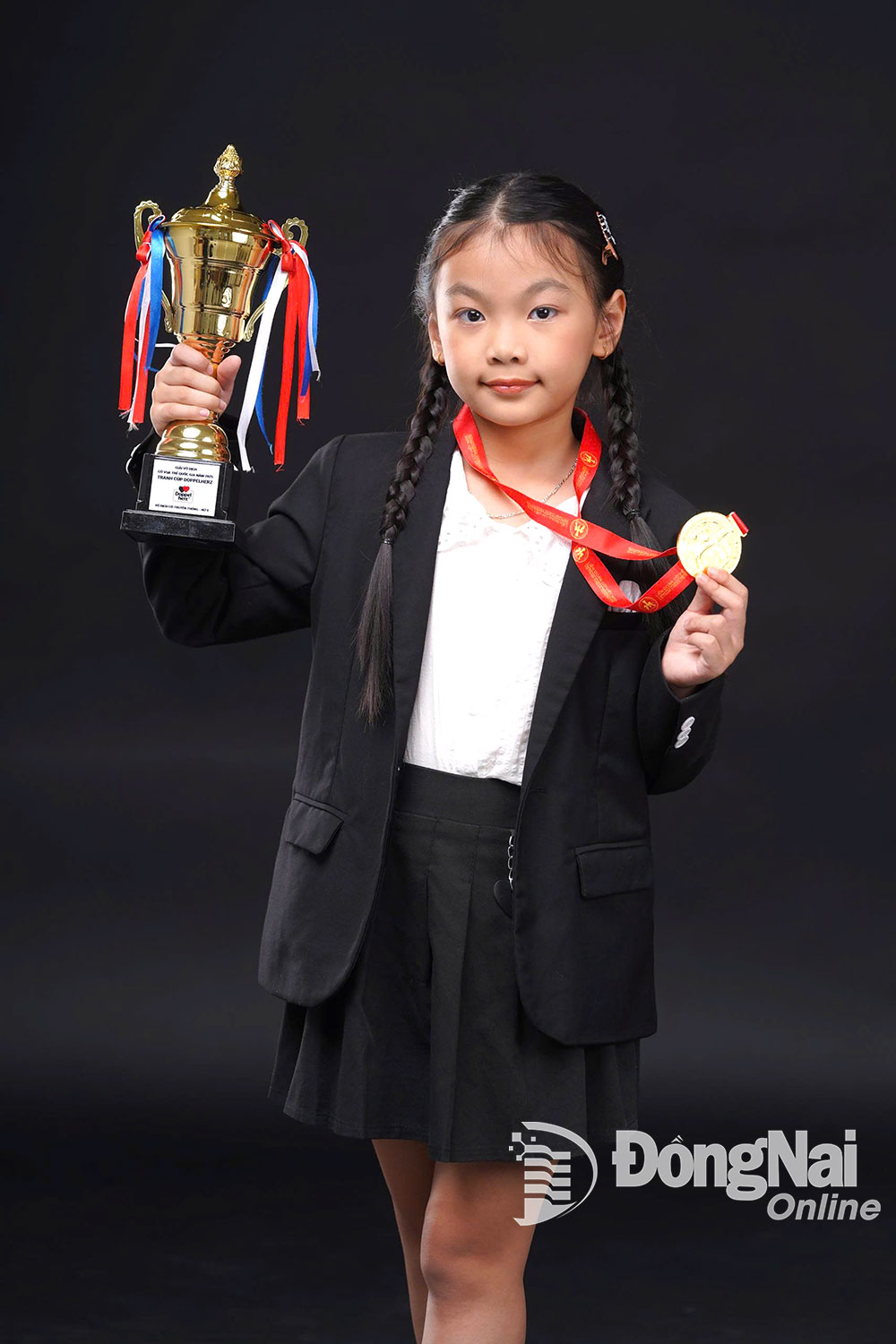 Kỳ thủ nữ 8 tuổi Ngũ Phương Linh với chiếc cúp vô địch giải trẻ quốc gia. Ảnh: NVCC