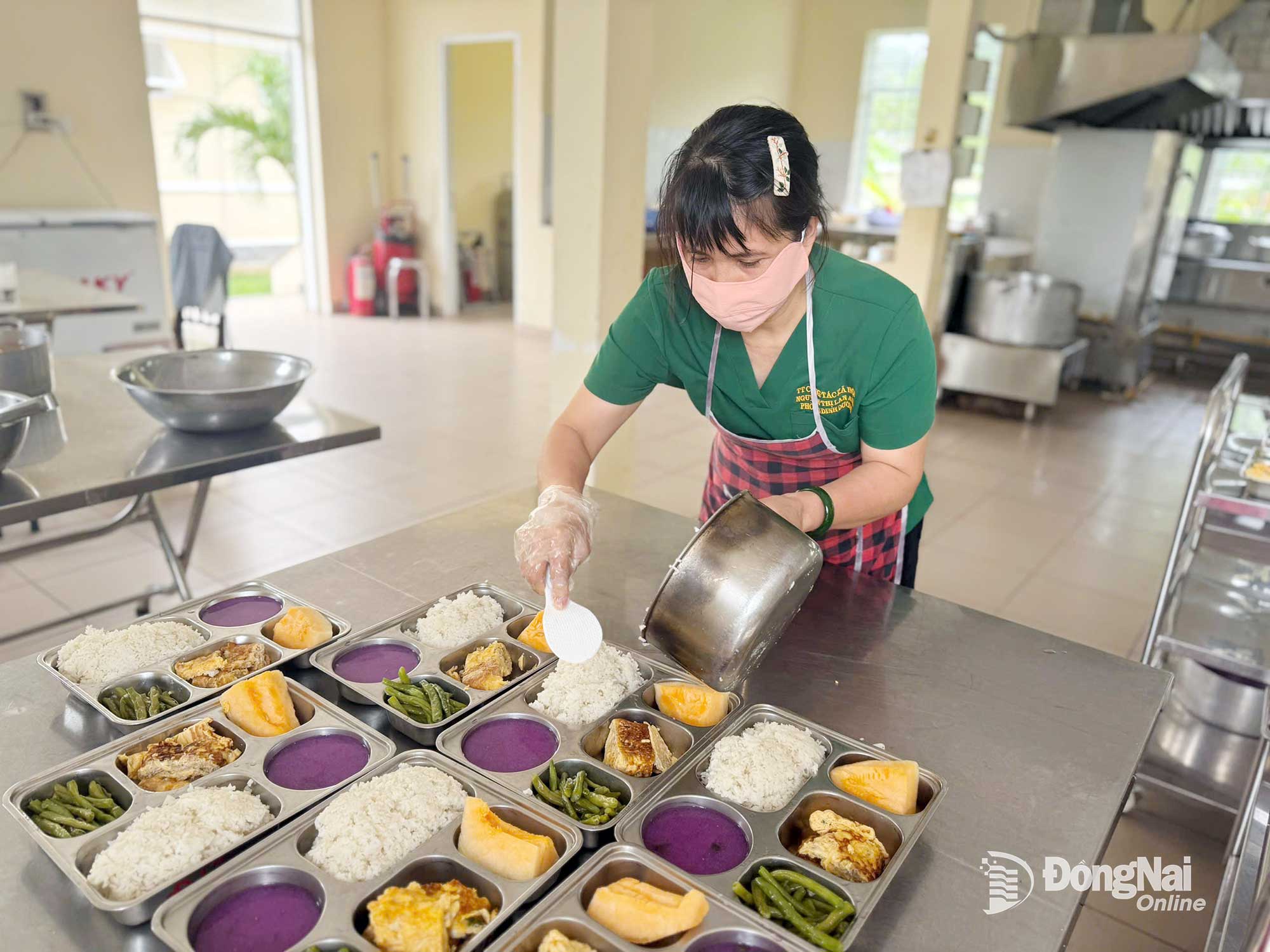 Nhân viên chuẩn bị cơm trưa cho những người đang sinh sống trong Trung tâm Công tác xã hội và Quỹ Bảo trợ trẻ em phường Tam Hiệp. Ảnh: Bích Nhàn