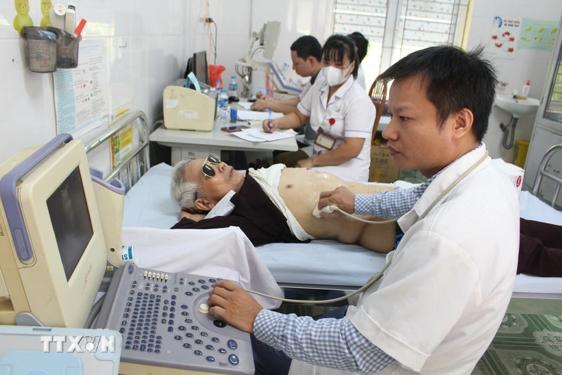 Các bác sỹ siêu âm cho người cao tuổi. (Ảnh: Nguyễn Thắng/TTXVN)