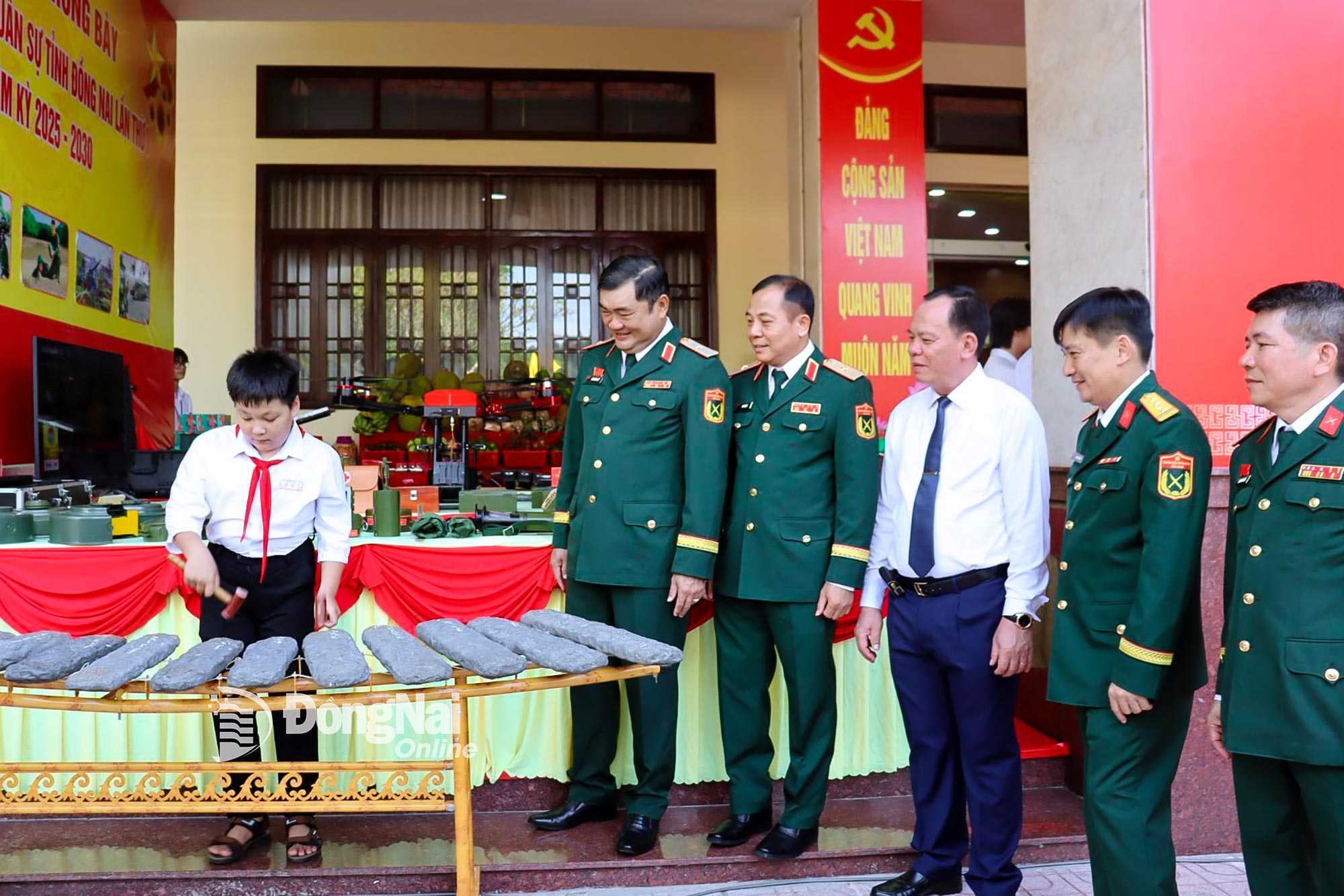 Thiếu tướng Lê Xuân Thế (thứ 2 từ trái qua), Phó Bí thư Đảng ủy, Tư lệnh Quân khu 7 và Phó Bí thư Tỉnh ủy, Chủ tịch UBND tỉnh Đồng Nai Võ Tấn Đức cùng các đại biểu tham quan mô hình đàn đá của học sinh - con nuôi đồn biên phòng của Lực lượng vũ trang Đồng Nai. Ảnh: Nguyệt Hà