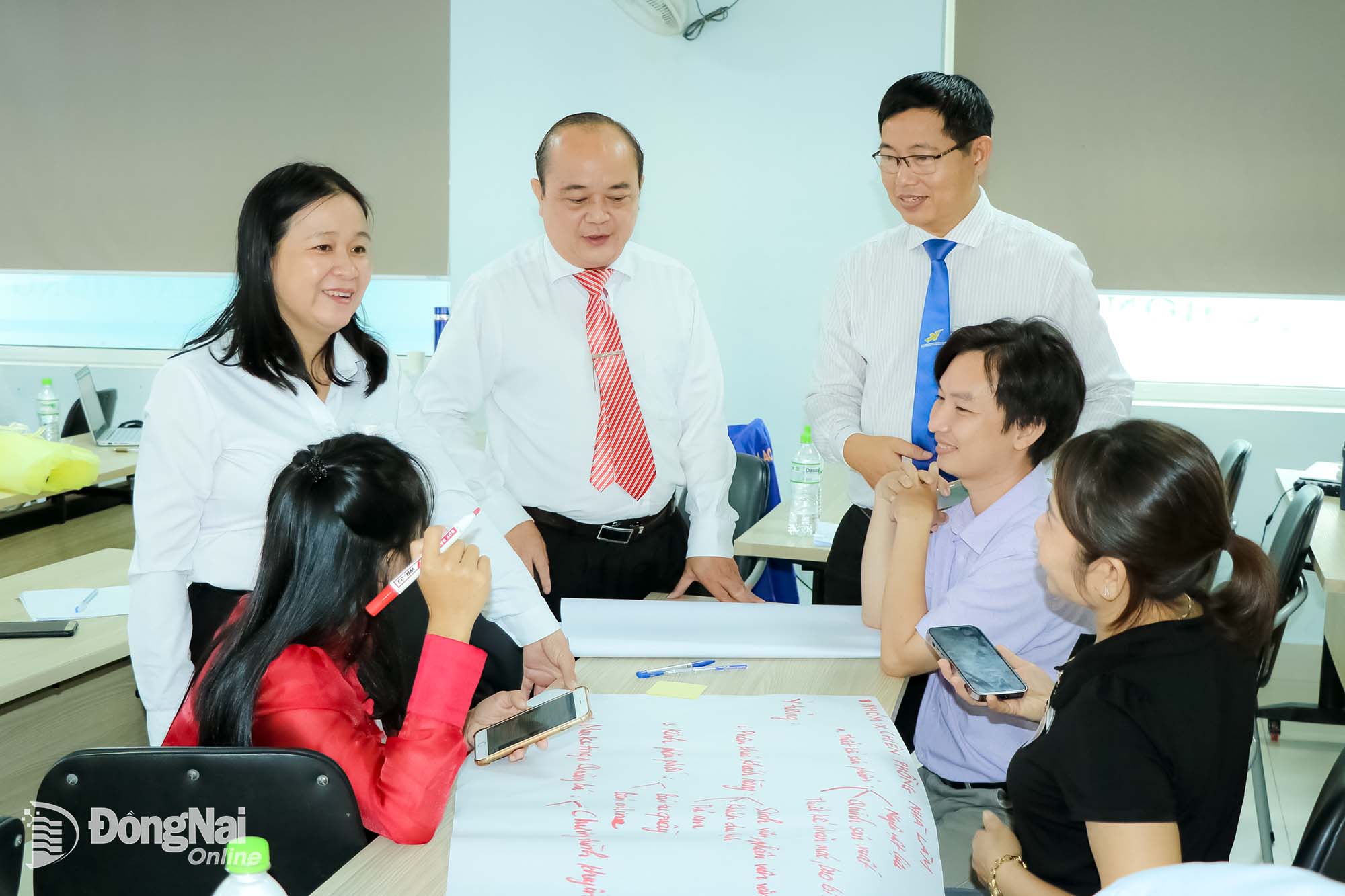 Phó Giám đốc Sở Khoa học và Công nghệ Võ Hoàng Khai (đứng giữa) trao đổi với các học viên trong lớp tập huấn cho giảng viên và cố vấn đào tạo khởi nghiệp  tại Trường đại học Lạc Hồng.