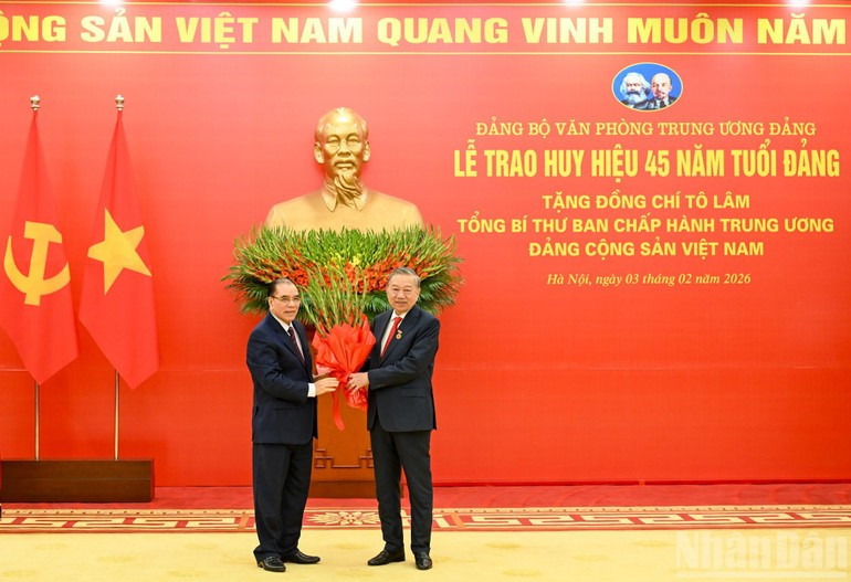 Nguy&ecirc;n Tổng B&iacute; thư N&ocirc;ng Đức Mạnh ch&uacute;c mừng Tổng B&iacute; thư T&ocirc; L&acirc;m nhận Huy hiệu 45 năm tuổi đảng.(Ảnh: DUY LINH)